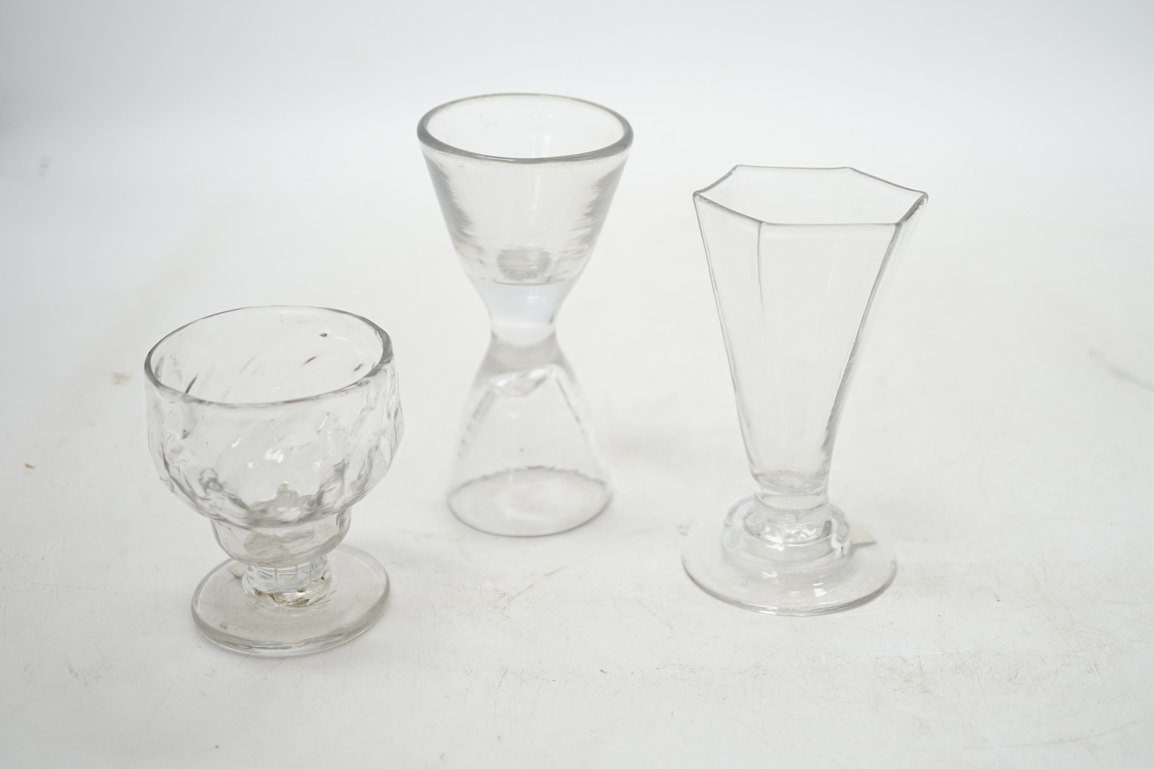 Three drinking glasses; a double ended glass, a bonnet glass and a hexagonal glass on stepped foot, tallest 11.5cm. Condition - good
